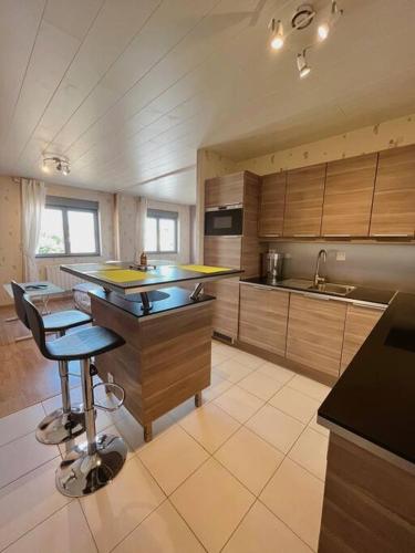 a kitchen with a island in the middle of it at L'Escale Des Voyageurs in Chalindrey