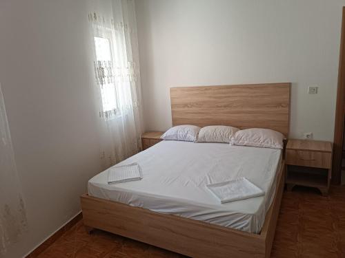 1 dormitorio con 1 cama grande y cabecero de madera en Accommodation Milla, en Ulcinj