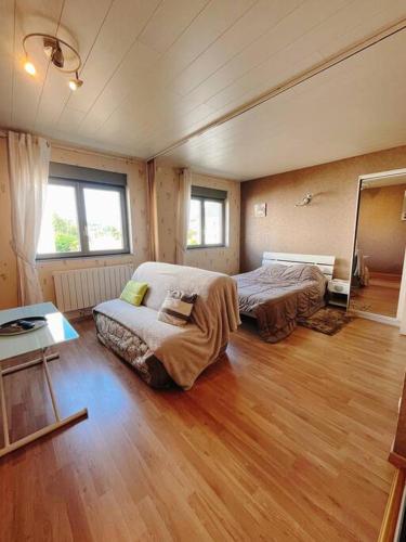ein Schlafzimmer mit einem Bett und einem Sofa darin in der Unterkunft L'Escale Des Voyageurs in Chalindrey
