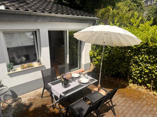 a table and chairs with an umbrella on a patio at Ferienwohnung Wuppertal Ronsdorf Elias Eller in Wuppertal