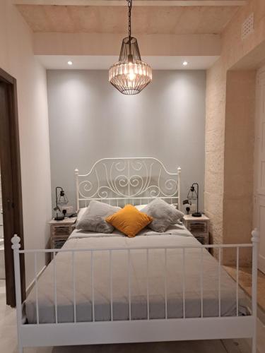 a bedroom with a bed and a chandelier at Ta' Wenzu in Birgu