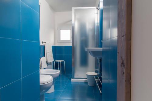 Motta CamastraにあるLa casa della nonnaの青いバスルーム(トイレ2つ、シンク付)
