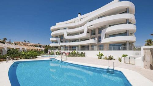 a building with a swimming pool in front of a building at Luxury frontline apartment in Aria Resort with Spa and Fitness in Fuengirola