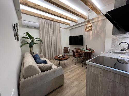 a living room with a couch and a kitchen at Supreme Malibu Suite in Alexandroupoli