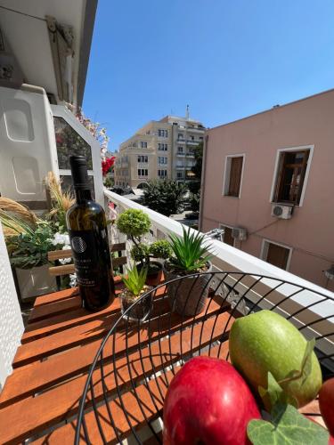 a bottle of wine sitting on a table with fruit on a balcony at Supreme Malibu Suite in Alexandroupoli