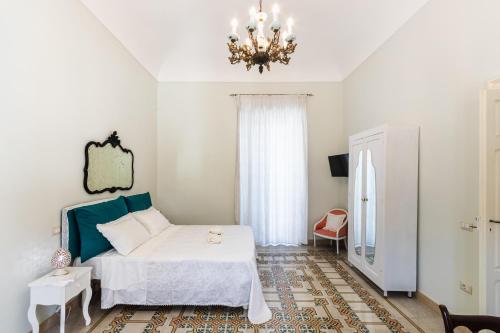 Schlafzimmer mit einem Bett und einem Kronleuchter in der Unterkunft Liberty Suite Regina Elena in Avola