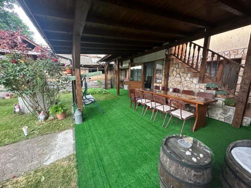a patio with green grass and a table and chairs at Къща за гости Даутев Връх in Bansko