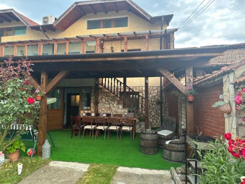 una casa y un patio con mesa y sillas en Къща за гости Даутев Връх en Bansko