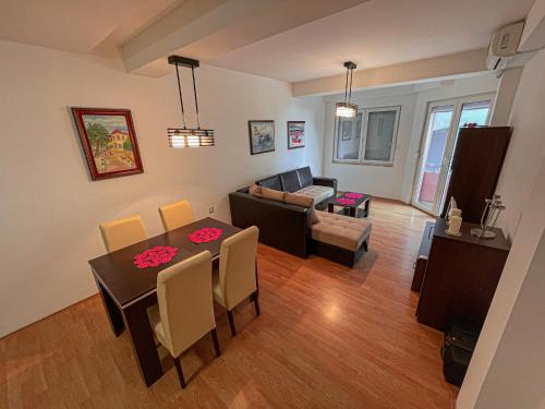 uma sala de estar com uma mesa e um sofá em Korun's Lakeview Apartment em Lagadin