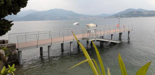 a pier on a lake with mountains in the background at Residenza del Pascià - Appartamento Camphora in Oggebbio