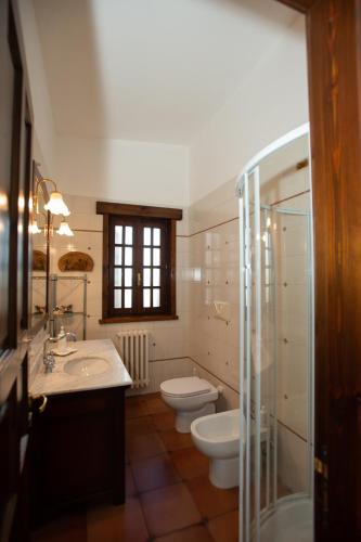 a bathroom with two toilets and two sinks and a shower at Villa del Ruach in Merine