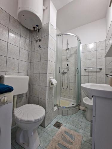 La salle de bains est pourvue d'une douche, de toilettes et d'un lavabo. dans l'établissement Apartment Šoštarić, à Krk