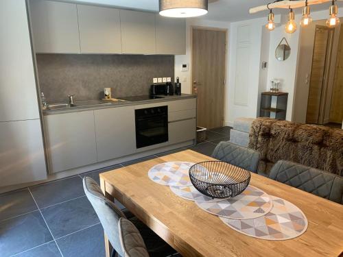 a kitchen and dining room with a wooden table at Studio neuf et chaleureux in Vars