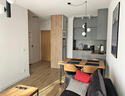 a living room and kitchen with a table and a couch at Apartamenty Westerplatte in Jastrzębia Góra