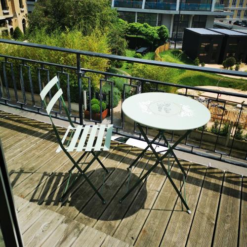 une table blanche et deux chaises blanches sur une terrasse dans l'établissement Résidence Zola, au Havre