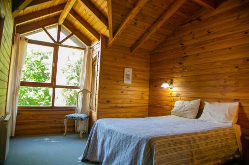 a bedroom with a bed in a wooden room at Cabañas Dulce Sofía in San Carlos de Bariloche