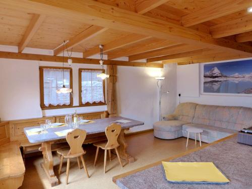a living room with a table and chairs and a couch at Chalet Tschingeli by Interhome in Niedergampel