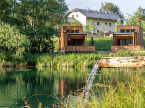 Blick auf einen See mit einem Haus im Hintergrund in der Unterkunft Apartment Glamping Lodge A by Interhome in Ossiach