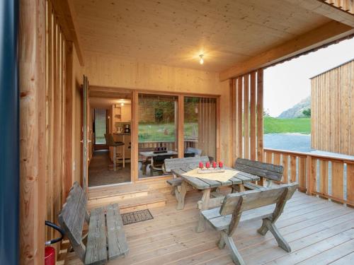 a porch of a cabin with benches and a table at Apartment Glamping Lodge A by Interhome in Ossiach