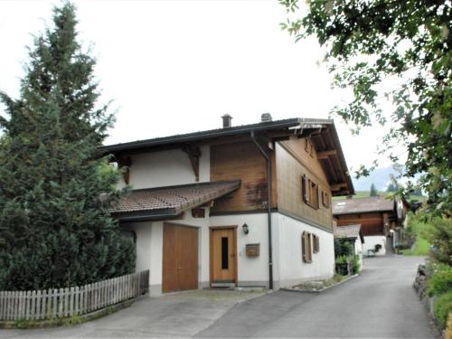 a house with a tree on the side of a road at Apartment Calanques by Interhome in Adelboden