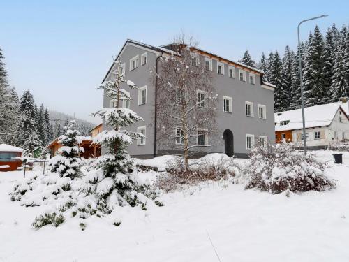 a large building in the snow with snow covered trees at Apartment Kořenov 720-2 by Interhome in Kořenov