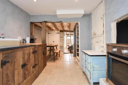 a kitchen with wooden cabinets and a table at Hastings Old town Cottage style in Hastings