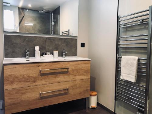 a bathroom with a sink and a mirror at Escale à Fécamp 4 étoiles - garage privé in Fécamp