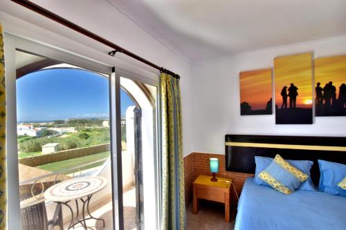 a bedroom with a bed and a balcony at Tonel Apartamentos Turisticos in Sagres