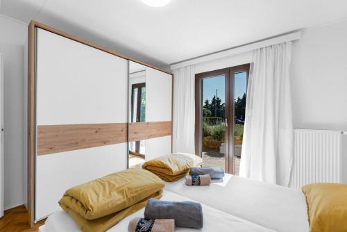 a bedroom with two beds and a large window at APP Sandro with Common Pool in Poreč