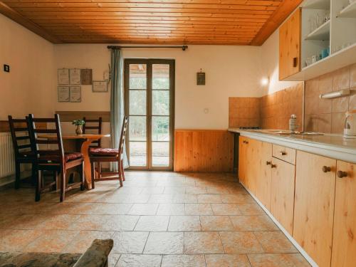 cocina con armarios de madera, mesa y comedor en Apartment Kačenka-1 by Interhome, en Desná
