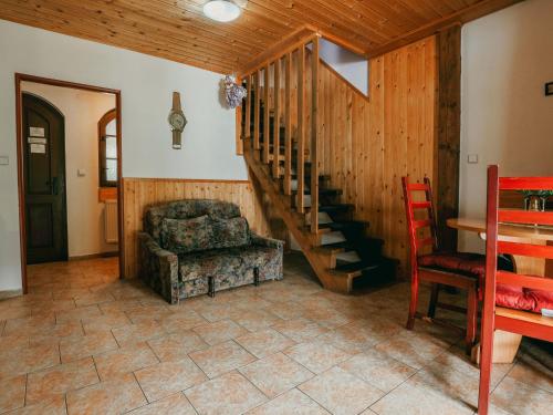 een woonkamer met een trap en een stoel bij Apartment Kačenka-1 by Interhome in Desná