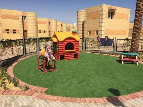 a playground with a play house and a table at New venecia resort in Ain Sokhna