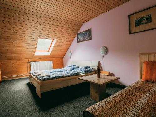 a bedroom with two beds and a wooden ceiling at Apartment Kačenka-3 by Interhome in Desná
