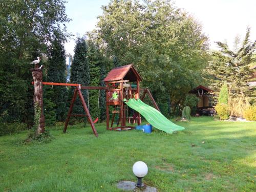 a playground in a yard with a swing set at Apartment Kačenka-3 by Interhome in Desná