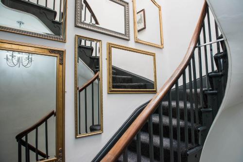 a bunch of framed mirrors on a wall with stairs at The Arches Apartments Kendal in Kendal