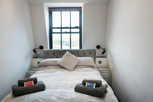 a bedroom with a bed with two pillows on it at The Arches Apartments Kendal in Kendal