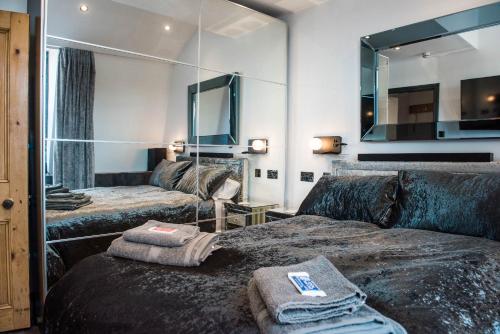 Habitación con 2 camas y espejo. en The Arches Apartments Kendal, en Kendal