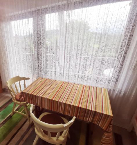 a table and chairs in front of a window at Ferienwohnungen Kremser bei Spiegelau Eppenschlag in Eppenschlag