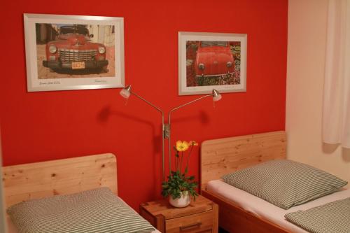 two beds in a room with red walls at Zum Torfstecher in Wilhelmsdorf