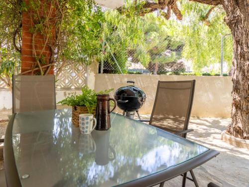 a glass table with two cups and two chairs at Holiday Home Oleg by Interhome in Torredembarra