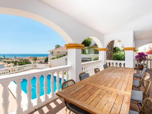 een houten tafel op een balkon met uitzicht op de oceaan bij Holiday Home Fragata House by Interhome in Cala del Moral