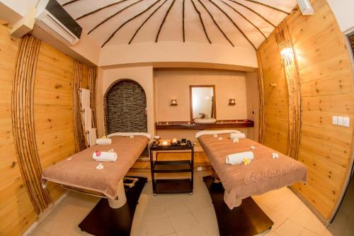 a spa room with two beds and a mirror at Movenpick Resort Lamantin Saly in Saly Portudal