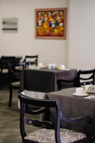 una sala da pranzo con tavoli e sedie e un tavolo con una sedia sidx sidx sidx di San Nicolas Plaza a San Nicolás de los Arroyos