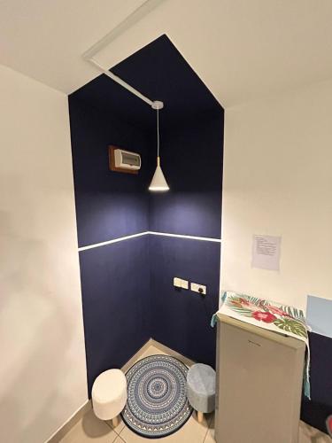 La salle de bains est pourvue d'un mur bleu et de toilettes. dans l'établissement Mabuti homestay, à Donggongon