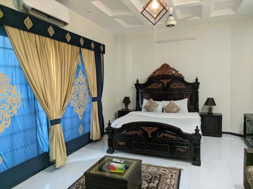 um quarto com uma cama grande e cortinas em White Palace Guesthouse em Islamabad