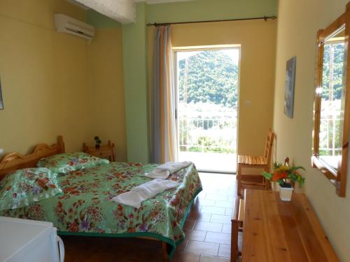 a bedroom with a bed and a window at Gregory's Studios in Paleokastritsa