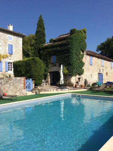 une grande piscine devant une maison dans l'établissement Le pigeonnier, à Le Verdier