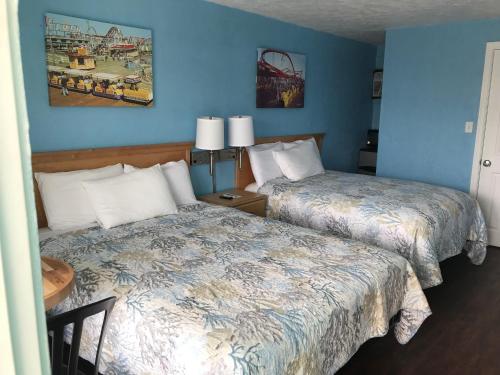 - 2 lits dans une chambre aux murs bleus dans l'établissement Surfcomber Motel, à Wildwood