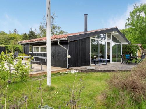ein kleines Haus mit einer Terrasse in der Unterkunft Holiday Home Stiane - all inclusive - 100m to the inlet by Interhome in Børkop