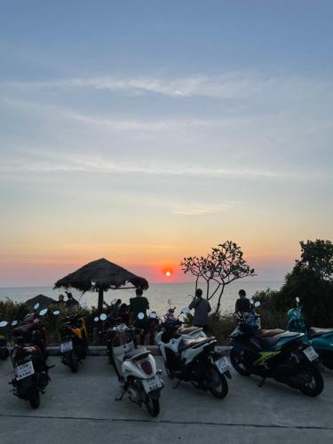 a group of motorcycles parked in front of a sunset at Apache Loongdum Koh Samed in Ko Samed